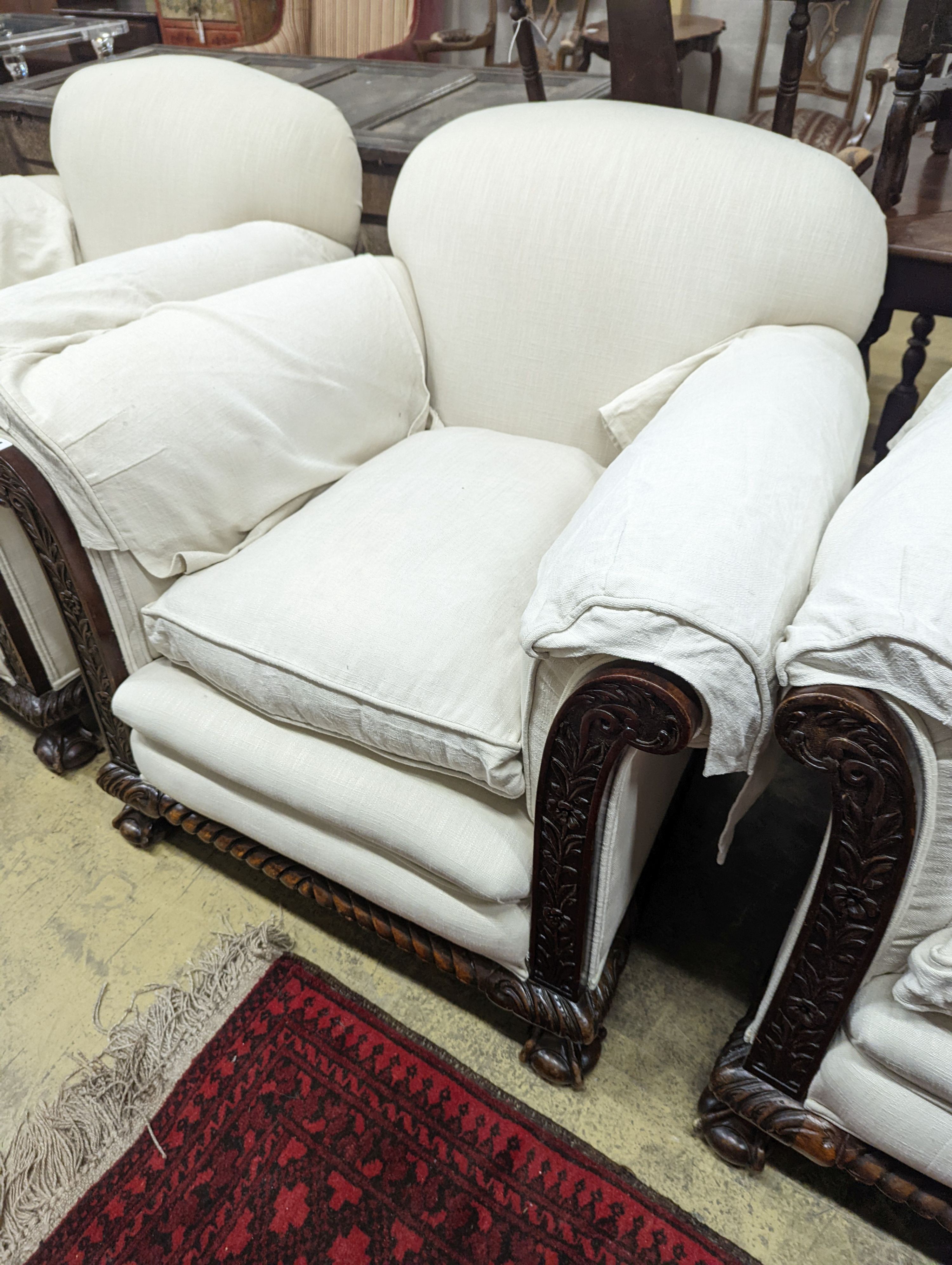 An early 20th century carved mahogany upholstered three piece lounge suite on claw and ball feet, the settee length 194cm, depth 80cm, height 80cm